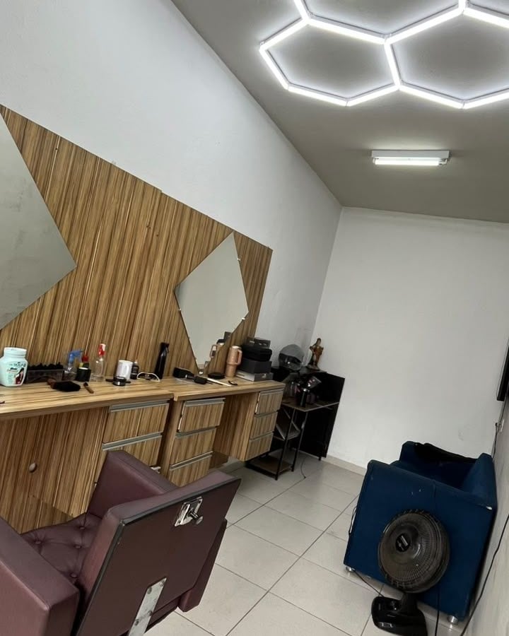 O salão por dentro, com a luz hexagonal no teto e a bancada de madeira