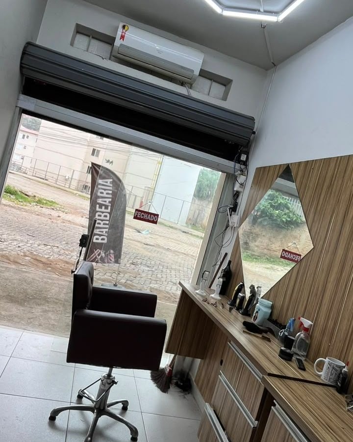 O salão visto da bancada, com a cadeira e a porta aberta para a rua